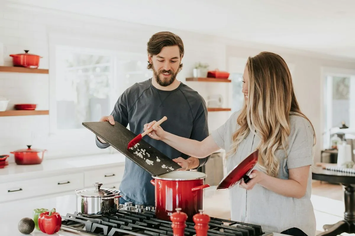 Couple préparant un repas dans une cuisine équipée ouverte de style contemporain
